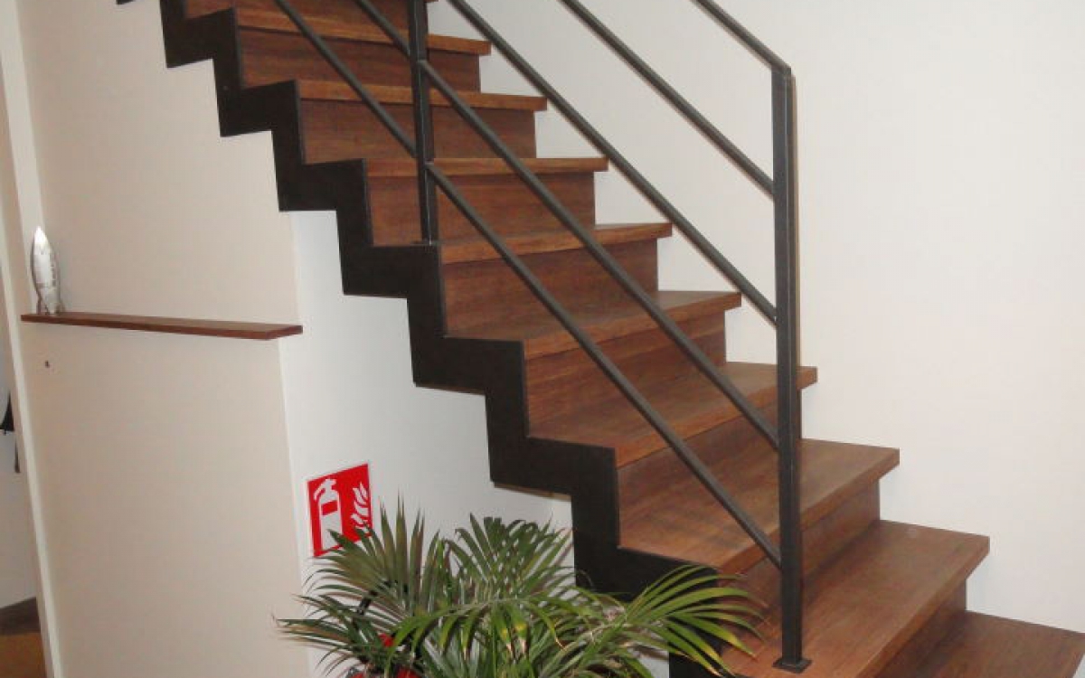 rechte trap met één zij trapboom, treden in hout, leuning in staal