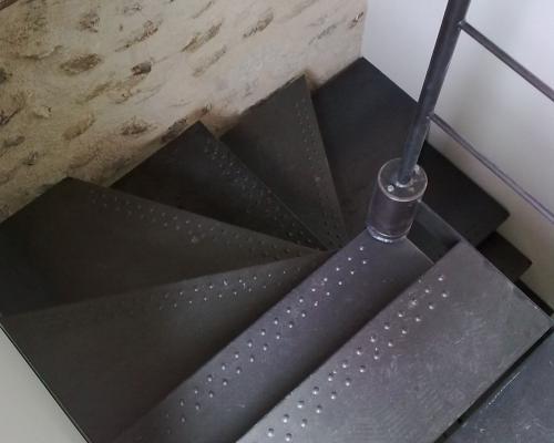 combinaison d'un escalier droit avec 1 poteau latéral et d'un escalier en colimaçon en acier. avec marches en acier avec profilage antidérapant