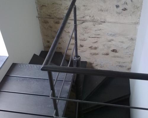 combinaison d'un escalier droit avec 1 poteau latéral et d'un escalier en colimaçon en acier. avec marches en acier avec profilage antidérapant