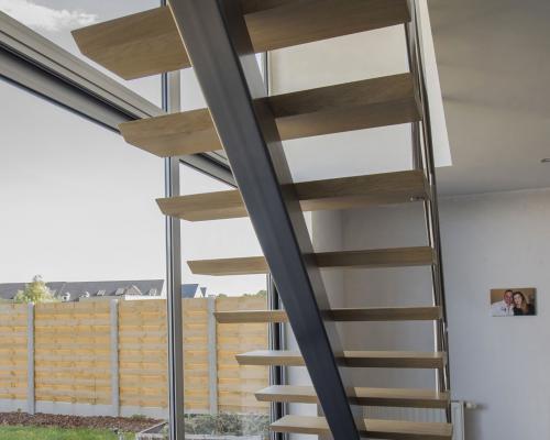 Rechte trap met één middenboom, treden eik naturel vernist, trapleuning en balustrade in inox 