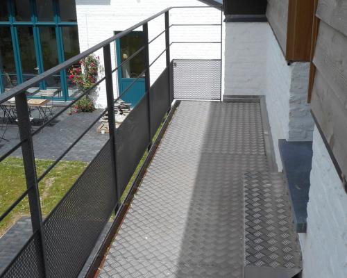 Stalen gelakte trap met treden in traanplaat-leuning met horizontale tussenstijlen-balustrade met perfo gecombineerd met horizontale tussenstijlen