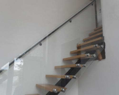 escalier avec 1 limon en acier - balustrade en verre et main courante en acier