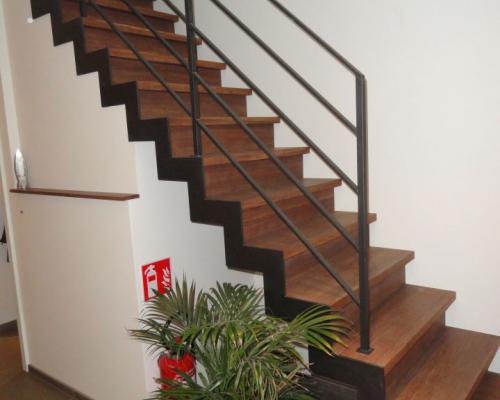 rechte trap met één zij trapboom, treden in hout, leuning in staal